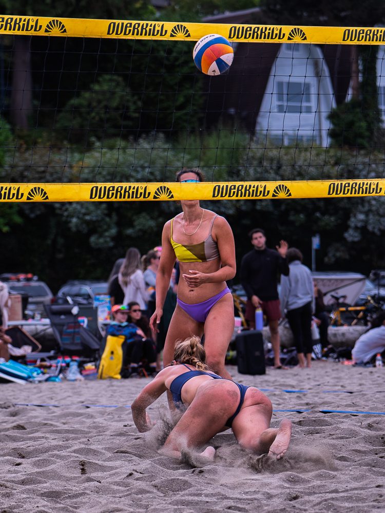 Player diving for a ball in front of a packed beach