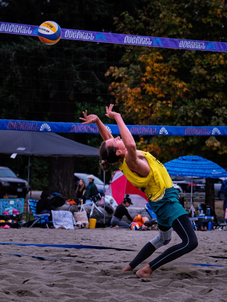 Player stretching for a high ball under the trees