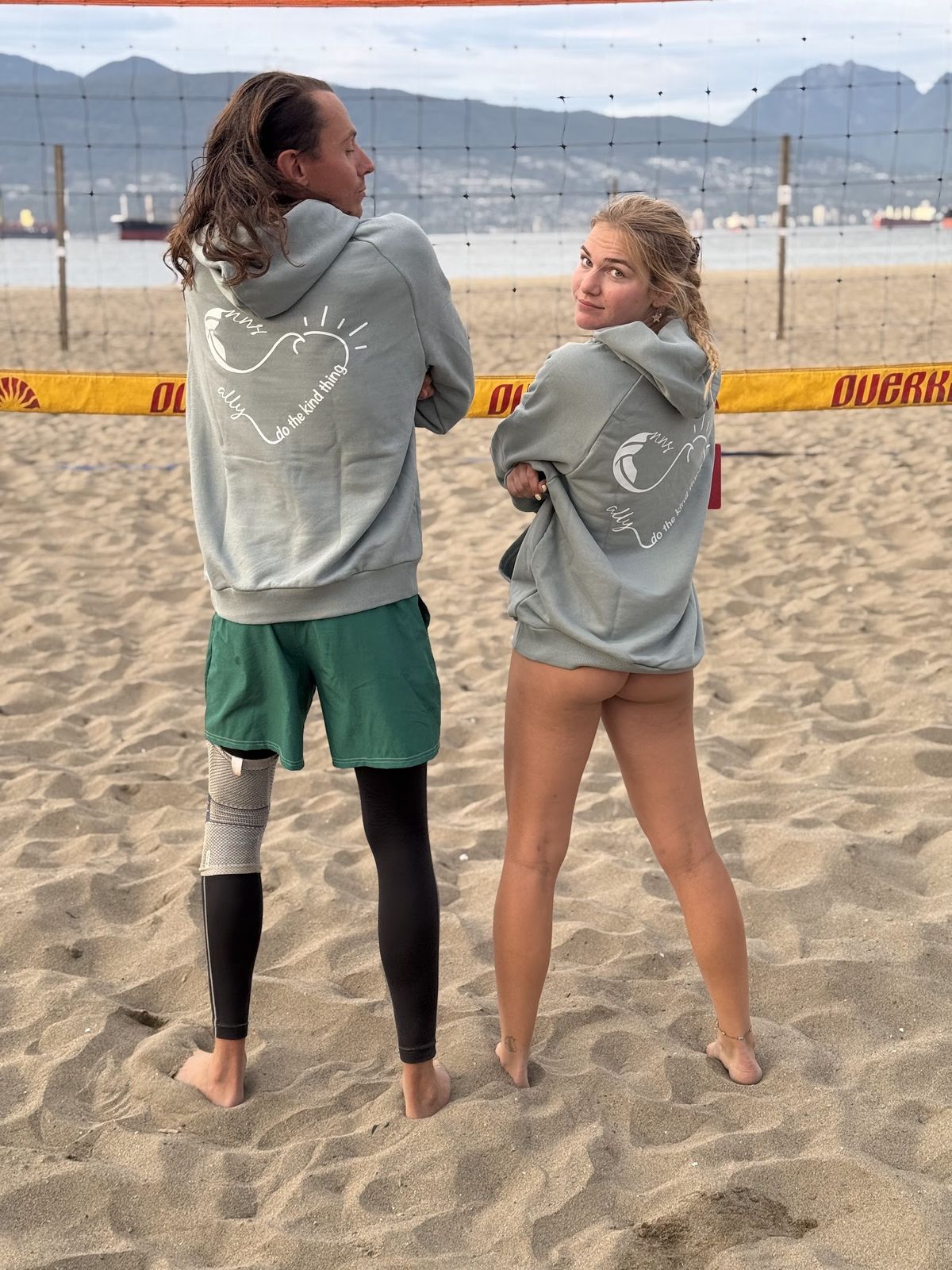 Two players in sage ALLY x NNS hoodies showing the heart print on the back