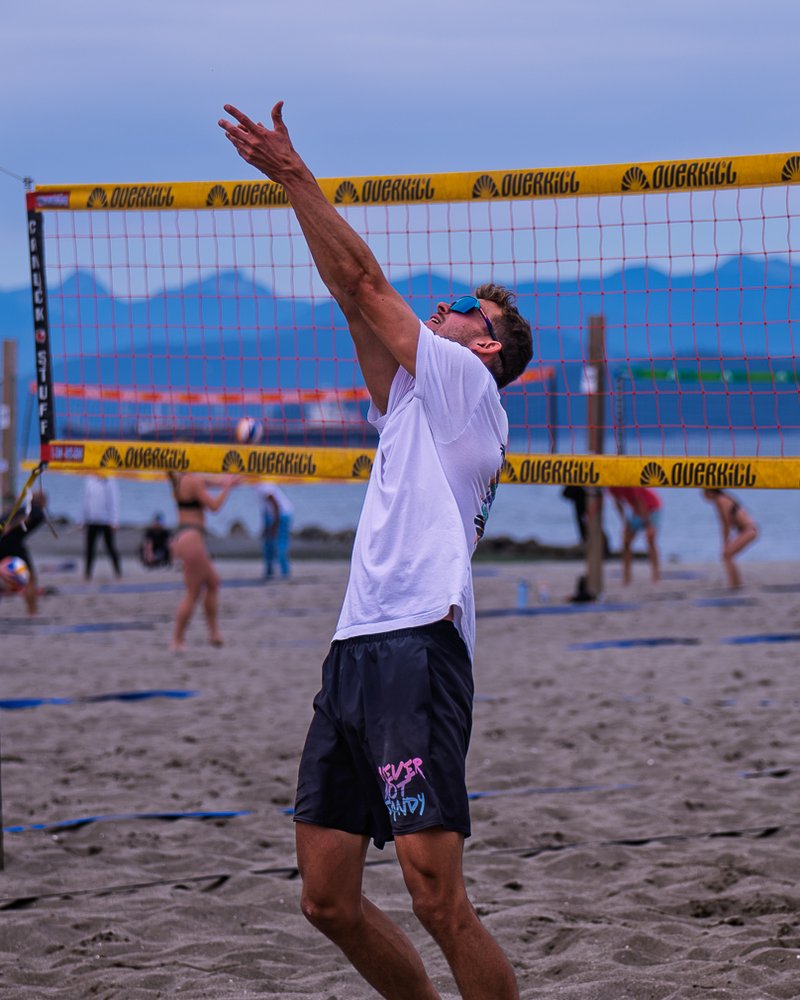 Player in black NNS Men's Shorts setting the ball at Spanish Banks